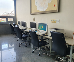 책상에 컴퓨터와 의자가 놓여있는 정보화실 내부 전경